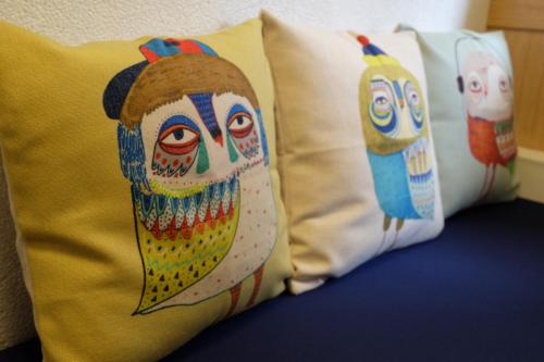 two pillows with owls on them sitting on a bed at Ming Shui Lu Homestay in Xingjian