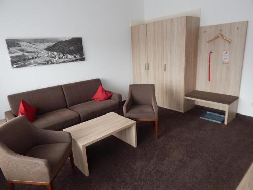 a living room with a couch and two chairs at BSW Schwarzwaldhotel Baiersbronn in Baiersbronn