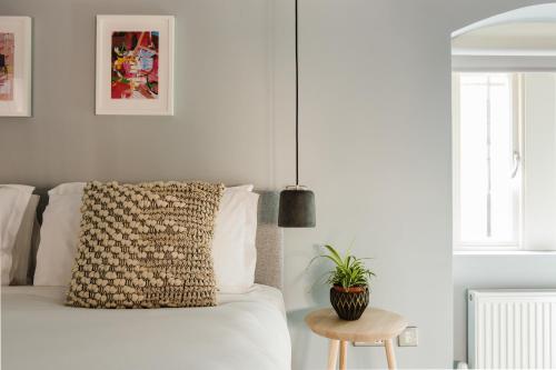 um quarto com uma cama com uma almofada e uma mesa em Hiding Space - St Catherine's Hospital Apartments em Bath