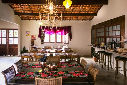 Pousada Zazen في فالي دو كاباو: غرفة طعام مع طاولة وكراسي وثريا