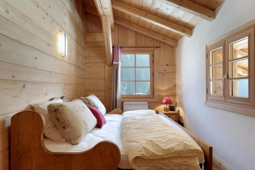 sypialnia z łóżkiem w drewnianym domku w obiekcie Chalet Ange w mieście La Giettaz