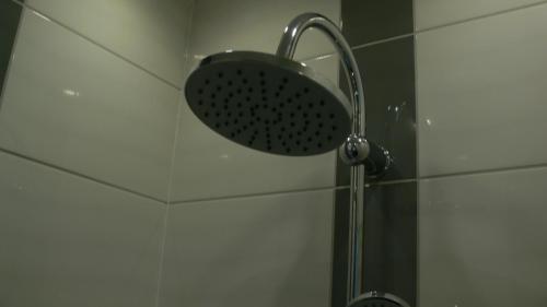 a shower with a shower head in a bathroom at Złota Leśniczówka in Rydzówka