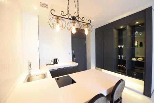 a kitchen with a sink and a table with chairs at Geoje Artnouveau Suite Hotel in Geoje 