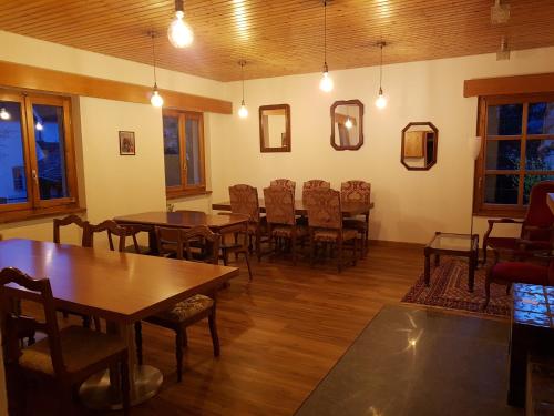 a dining room with wooden tables and chairs at Cuore Alpino in Olivone