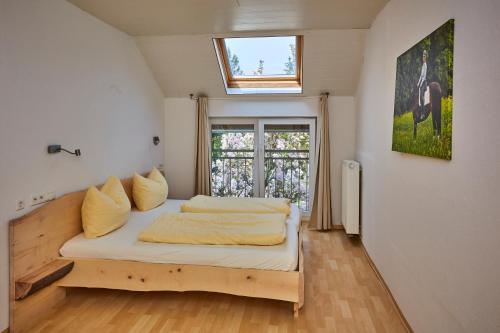 a bedroom with a bed with a window at Urlaubsreiterhof Trunk in Igersheim