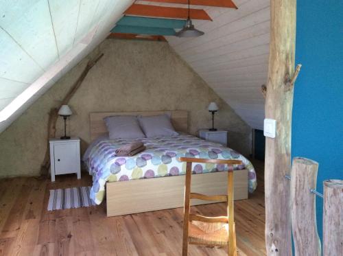 une chambre avec un lit dans un grenier dans l'établissement La vieille ferme, à Landévennec