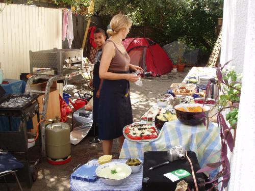 una mujer parada frente a una mesa de comida en Gerry `s Backpacker en Konstanz