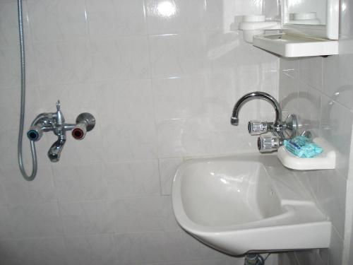 a white bathroom with a sink and a shower at Villa Exotica in Balchik
