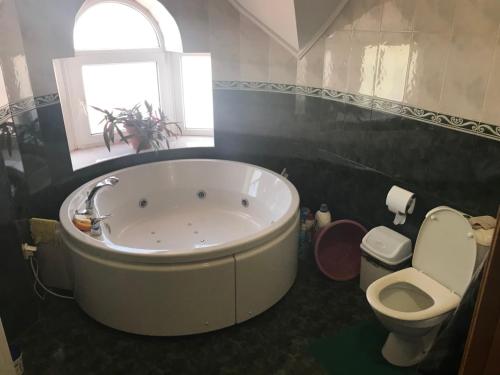 La salle de bains est pourvue d'une baignoire, de toilettes et d'une fenêtre. dans l'établissement Lorena, à Odessa