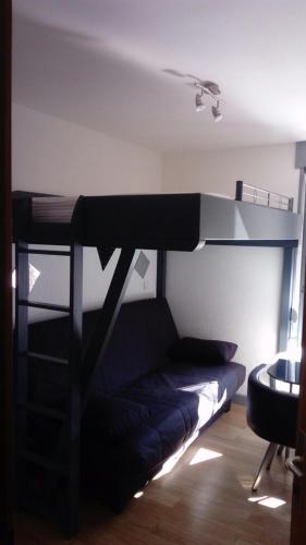 a black bunk bed in a room with a couch at studio des écureuil in Gérardmer