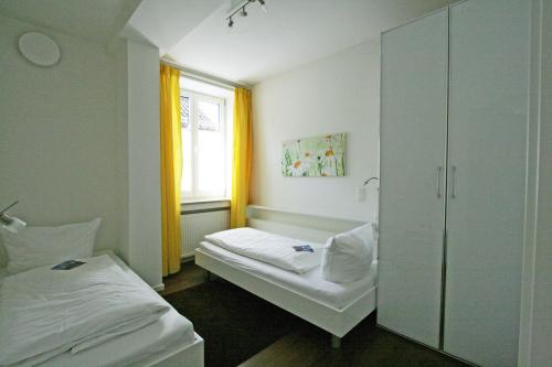 Cette chambre comprend 2 lits et une fenêtre. dans l'établissement Ferienwohnung Am Kurpark - Wohnung 1,60qm-, à Garmisch-Partenkirchen