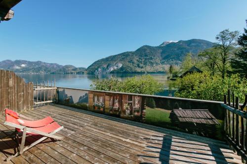a deck with a chair and a view of a lake at Seegasthof Gamsjaga in Sankt Gilgen