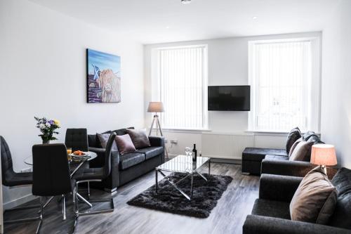 a living room with two couches and a tv at Casa Fresa - King Street Apartments in Dundee