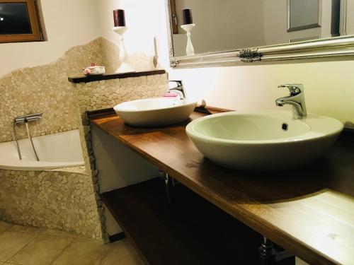 a bathroom with two sinks on a wooden counter at Romantic Cottage House in Žužemberk