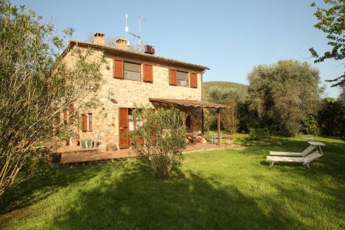an old stone house with a bench in a yard at Casale Vigna Carbona in Gavorrano