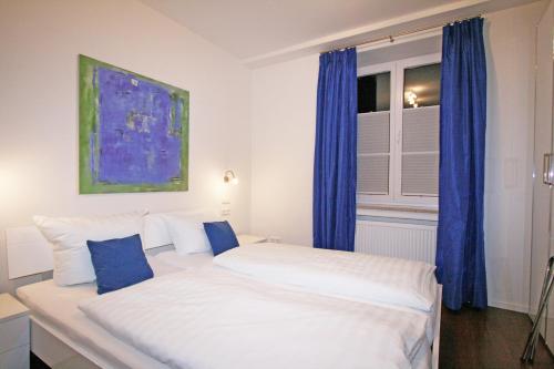 1 dormitorio con 2 camas y una ventana con cortinas azules en Ferienwohnung Am Kurpark -Wohnung 2,90qm- en Garmisch-Partenkirchen