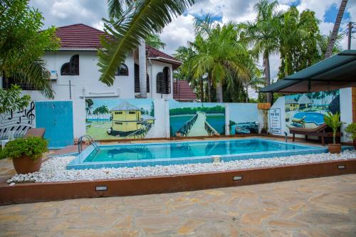 a swimming pool in front of a house at Daisy Comfort Home in Dar es Salaam