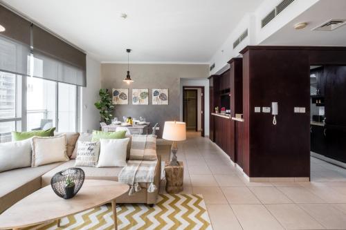a living room with a couch and a table at Maison Privee - Exclusive Apt with Burj Khalifa Next Door in Dubai