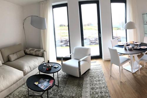 a living room with a couch and a table and chairs at Tor zum Meer in Helgoland