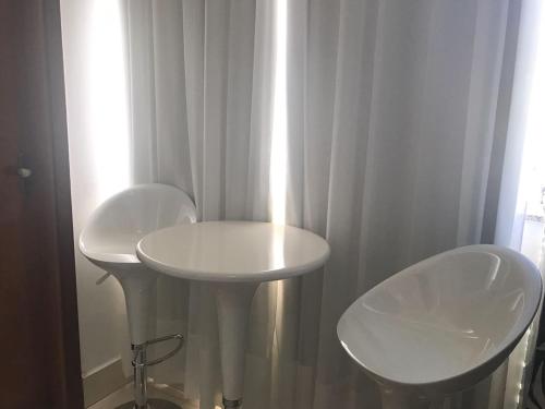 La salle de bains est pourvue de 2 lavabos blancs et de 2 chaises. dans l'établissement Encontro das Águas Thermas Resort, à Caldas Novas