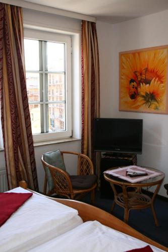 a hotel room with a bed and a desk and a television at Hotel Village in Celle