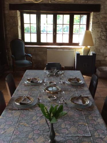 a dining room table with plates and glasses on it at Chambre d'hotes la Quercynoise in Montaigu-de-Quercy