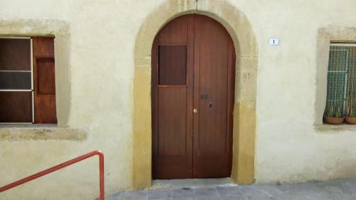 une porte en bois sur le côté du bâtiment dans l'établissement Tipica casa d'altri tempi, à Furnari