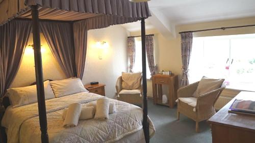 a bedroom with a canopy bed and a chair at Wheelgate in Torver