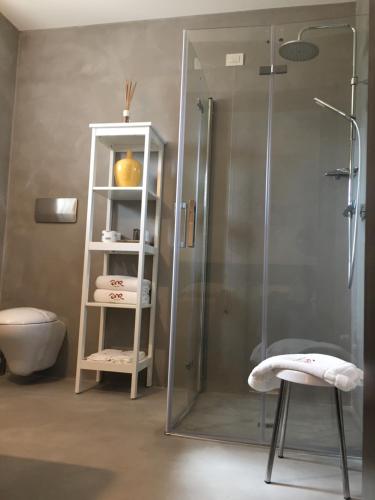 a bathroom with a shower with a stool next to a stool at Abate Masseria & Resort in Noci