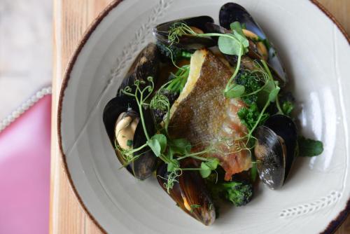 a plate of food with mussels and vegetables on a table at The Litton in Litton