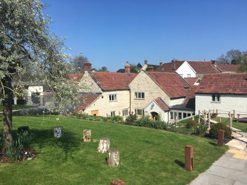 a group of houses in a yard with trees at The Litton in Litton