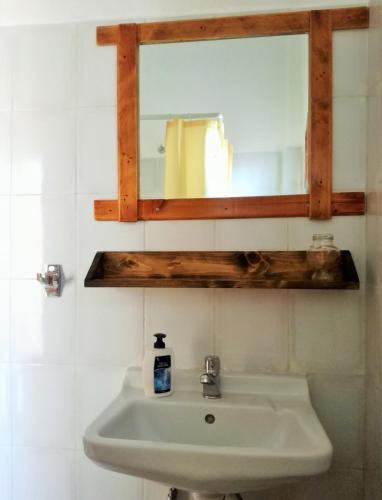 a bathroom with a sink and a mirror at Arleta's Sunny Guesthouse in Prinos