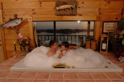 Dos personas sentadas en una bañera llena de espuma en Sugar Ridge Resort en Eureka Springs