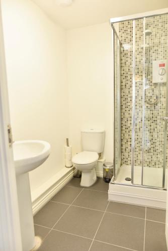 a bathroom with a toilet and a sink and a shower at Smartrips Apartments in Coventry