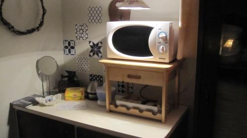 a microwave sitting on top of a wooden stand at Eriks Bädd och Pentry in Hillerstorp