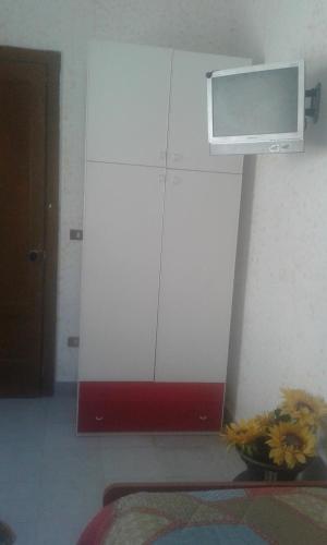 a white cabinet with a microwave on the wall at Locanda Amato in Amato