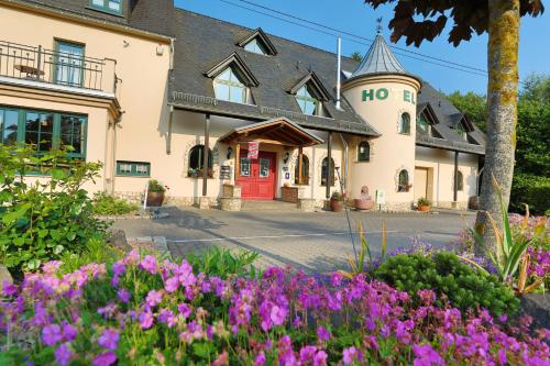a building with purple flowers in front of it at Landhotel Villa Moritz garni in Oberahr