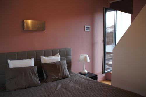 sypialnia z łóżkiem, lampką i oknem w obiekcie All Inn Holiday Home w Gandawie