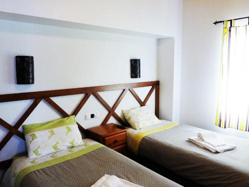 una camera d'albergo con due letti e una finestra di Lucas House 1 ad Aljezur