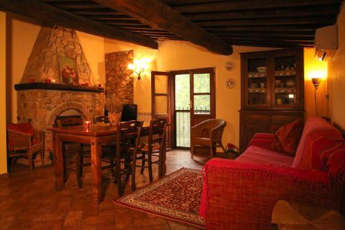 a living room with a table and a fireplace at Casale Vigna Carbona in Gavorrano