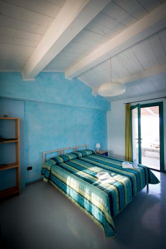 a bedroom with a bed in a blue room at Agriturismo La Tana di Lu Maccioni in Santa Teresa Gallura