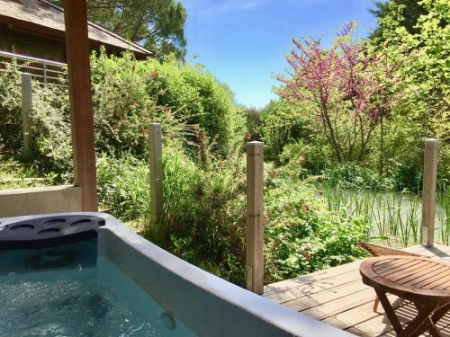 a swimming pool in a backyard with a table and a table at Le Mas de l'Espérance - Chambres d'hôtes de Prestige in Garons