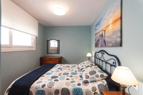 a bedroom with a bed with a comforter at Lets Holidays RENOVATED APARTMENT NEAR BEACH in Tossa de Mar