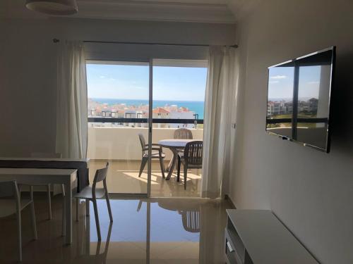 a living room with a table and chairs and a window at Marina Golf Appart Chez Hicham in Asilah