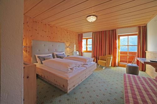 a hotel room with two beds and a desk at Landgut Thalerhof in Telfes im Stubai