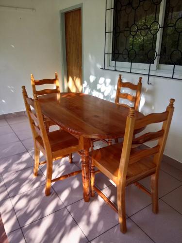 a wooden table and two chairs sitting next to a window at Awesome Charlie D Villas in Anse Kerlan