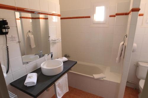 a bathroom with a sink, toilet and bathtub at Hotel de La Paix in Corte