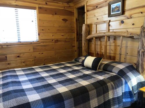 a bedroom with a bed in a log cabin at Mountain View Lodge & Cabins in Hill City