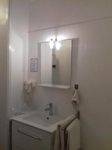 a white bathroom with a sink and a mirror at Le Magiot in Montliot-et-Courcelles