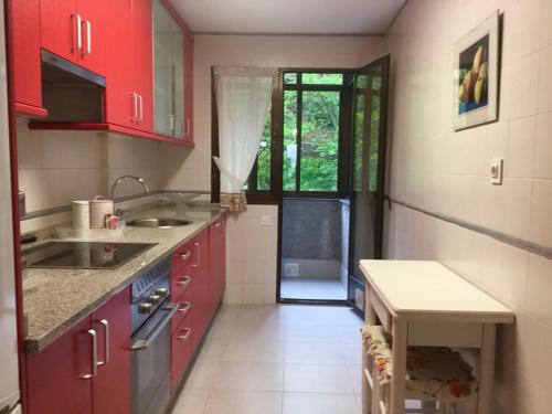 サリナスにあるSalimar 23の赤いキャビネットとテーブル付きのキッチンが備わります。